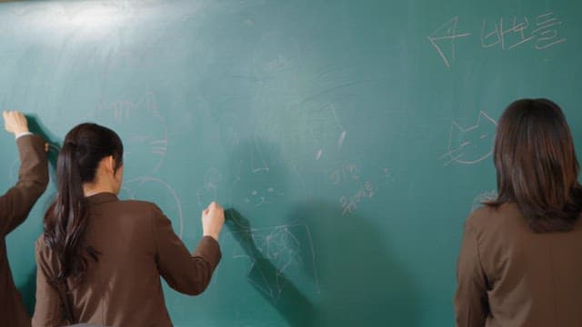 Students scribbling on a classroom blackboard