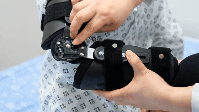 Doctor adjusting patient's arm brace