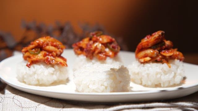 Abalone seasoned on rice balls plated on a white plate