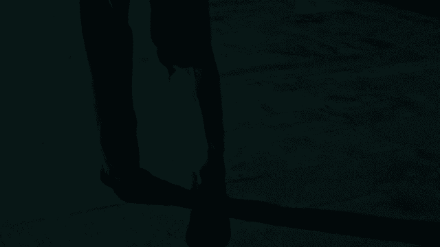 Man in a suit walking down a dark street at night