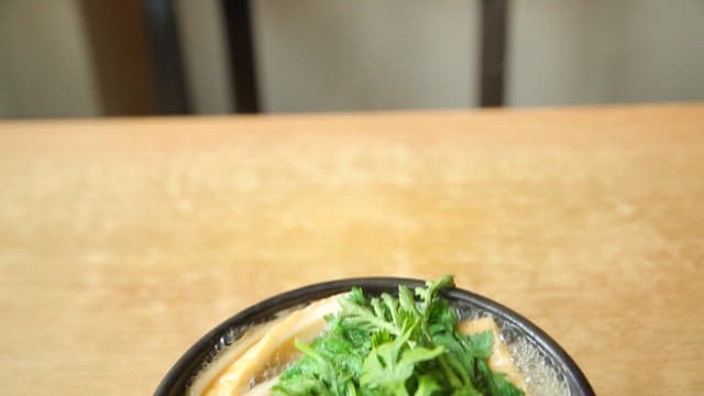 Bowl of warm udon noodles with fish cake and vegetables