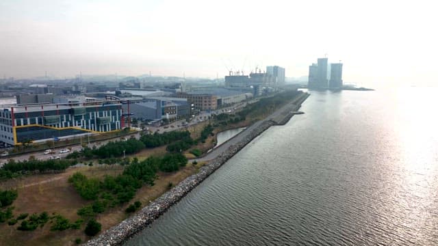 밝은 해가 비치는 물가의 산업 단지