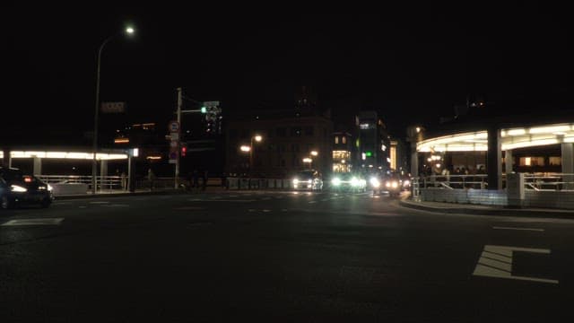 Cars passing through a busy intersection at night