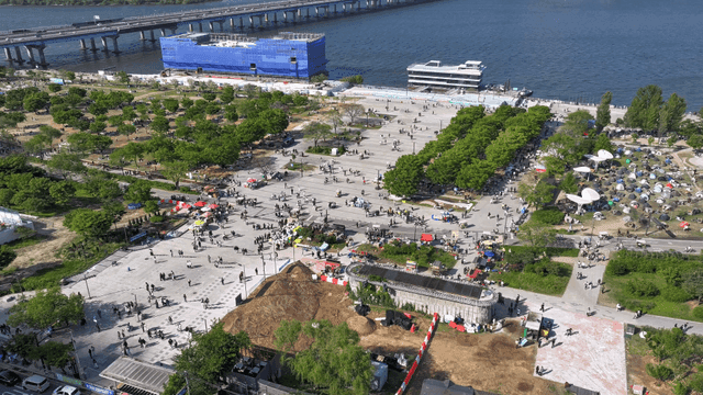 텐트와 사람들이 있는 강변 공원의 활기찬 모습