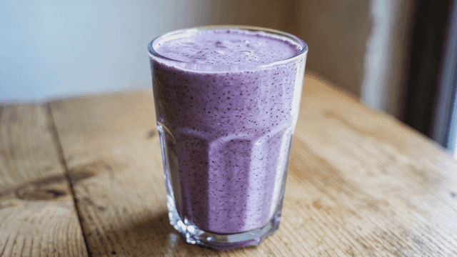 나무 테이블 위의 블루베리 스무디 한 잔