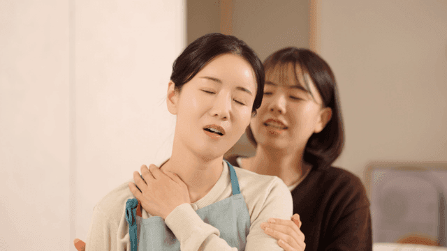 Mom getting shoulder massage from her daughter at home