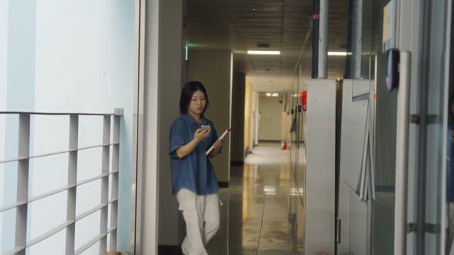 Woman walking in a hallway with a phone