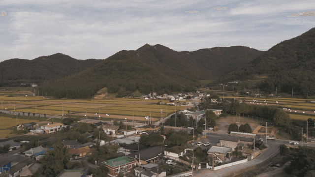 Rural village surrounded by fields and mountains