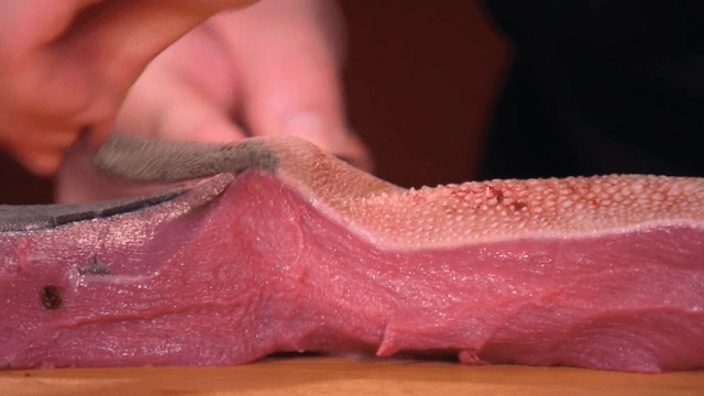 나무 도마 위에서 우설을 손질하는 사람