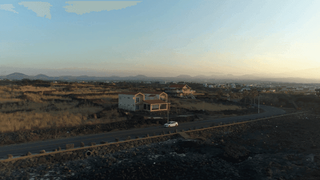 Narrow road in rural landscape at sunset