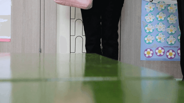 Person picking up slippers indoors