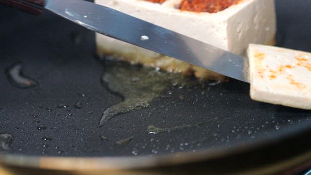 Tofu sizzling in a frying pan