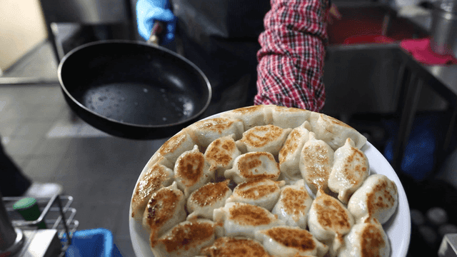 Freshly fried dumplings on plate placed upside down in pan