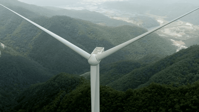Wind turbine in a lush green mountain area