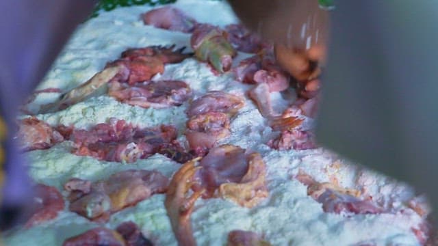 Placing fresh chicken on top of the manioc dough