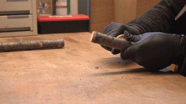 실내에서 나무 막대로 작업하는 사람