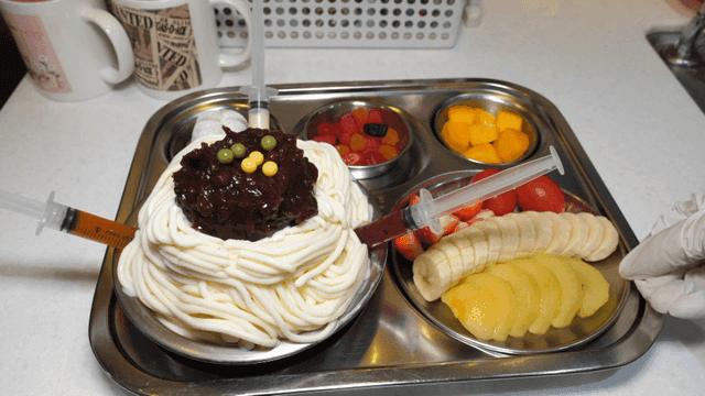 주사기와 과일이 있는 독특한 디저트