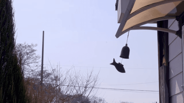 지붕 아래서 흔들리는 전통 모양의 종