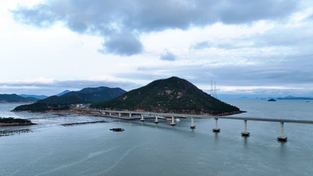 산이 보이는 바다 위의 다리