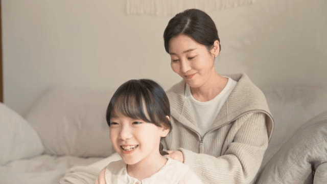 Mother braiding her daughter's hair