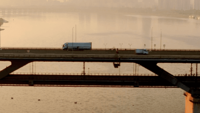 Cars crossing a bridge at sunset