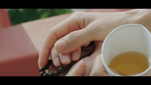 염주 팔찌를 건네는 손