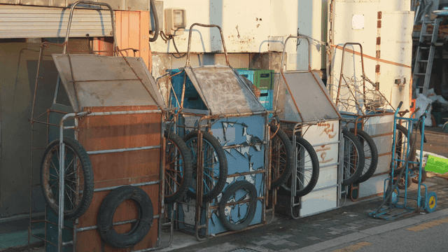 Old carts lined up in front of scrap metal shop