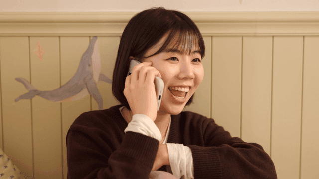 Young woman talking on phone on her smartphone in her room