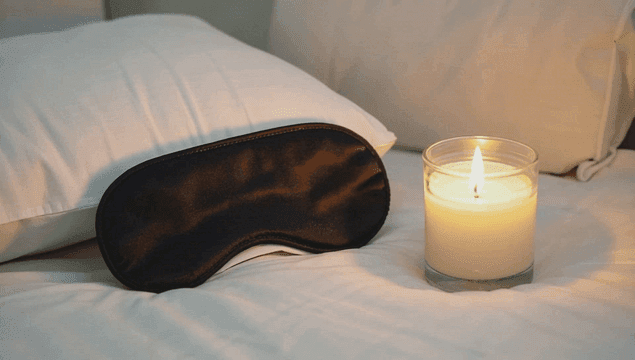 침대 위의 수면 안대와 양초