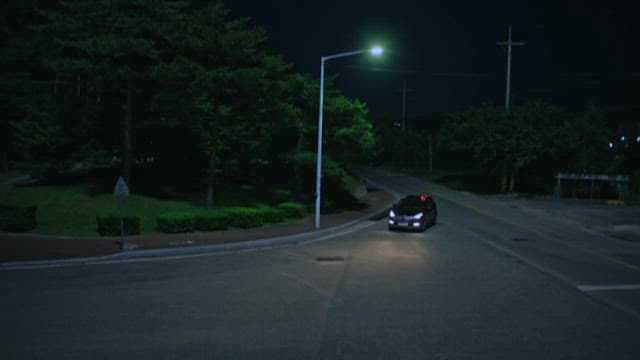 밤거리의 한적한 도로를 지나가는 자동차