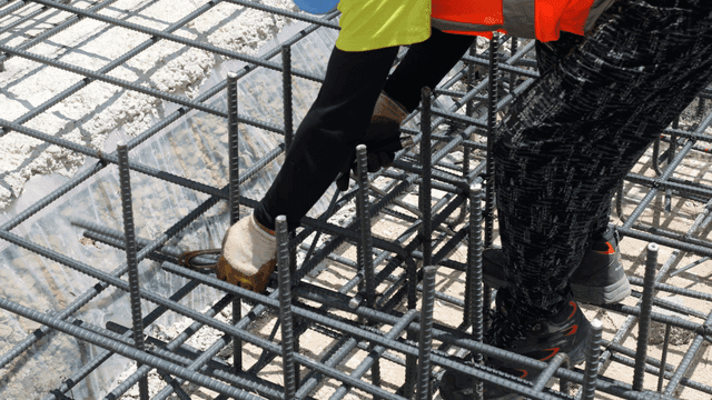 Worker tying rebar at a construction site