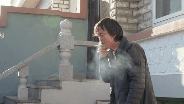 건물 밖에서 담배를 피우는 남자