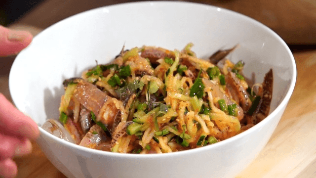 Putting cold raw fish soup in a bowl with ice