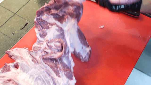 Butcher preparing raw meat on a board