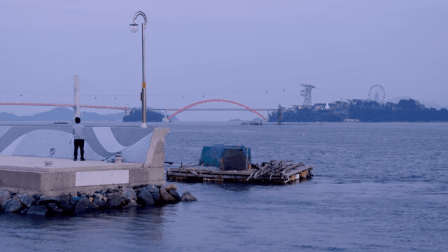 해질녘 바닷가에서 낚시하는 사람