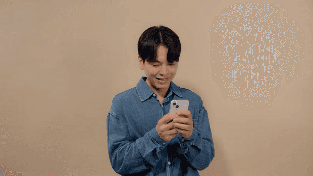 핸드폰으로 메시지를 주고 받으며 웃는 남성