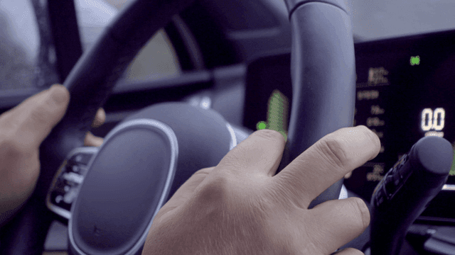 Hands gripping a steering wheel inside a car