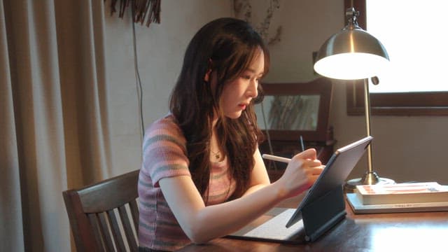 Woman studying with a tablet indoors