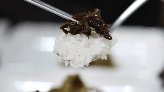 Spoonful of rice with side dish of vegetables