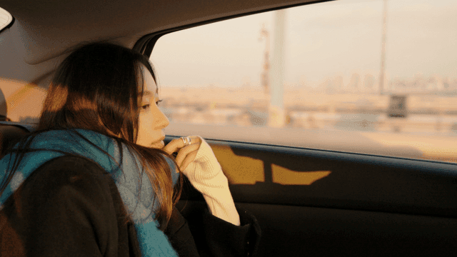 Woman looking out the window of a taxi crossing a bridge