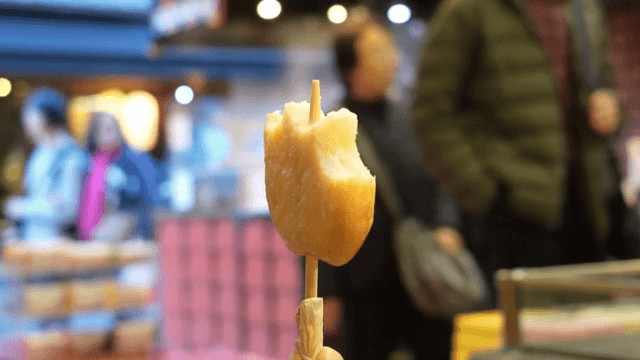 시장에서 튀김이 꽂힌 꼬치 먹기