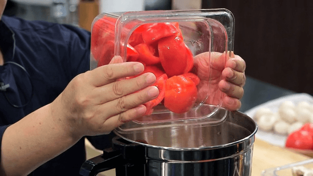 Tomatoes being added to a pot
