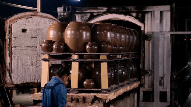 가지런히 놓인 전통 항아리를 점검하는 작업자