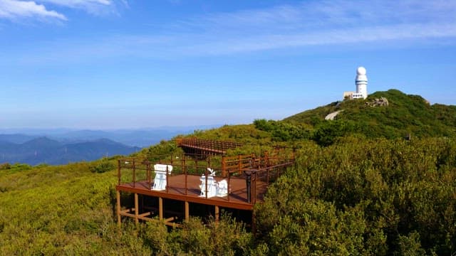 Observation deck on a lush green mountain with a white observatory