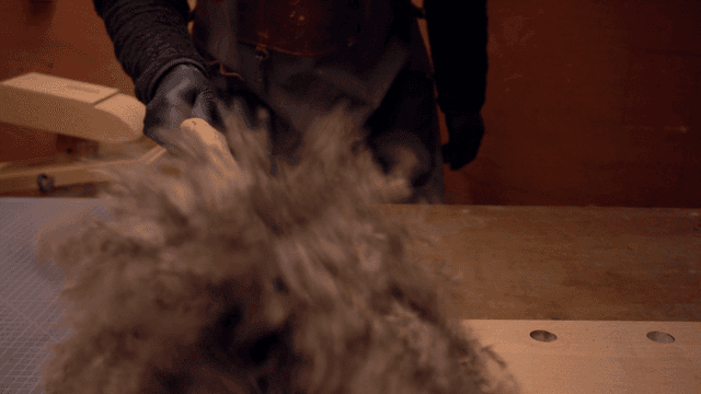 Person crafting a handmade broom indoors