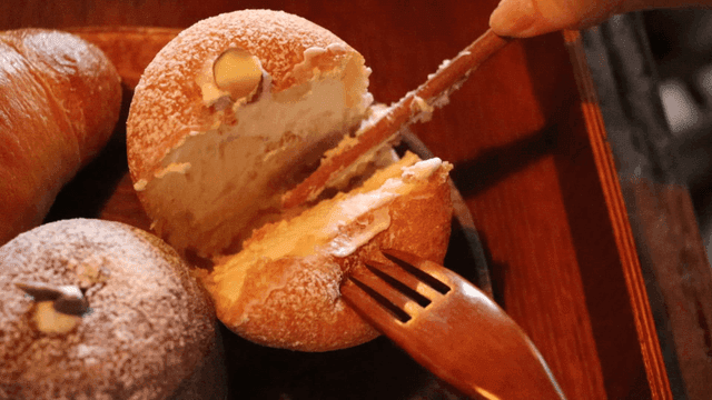 크림이 든 페이스트리를 자르는 사람