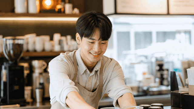 미소로 커피를 제공하는 바리스타