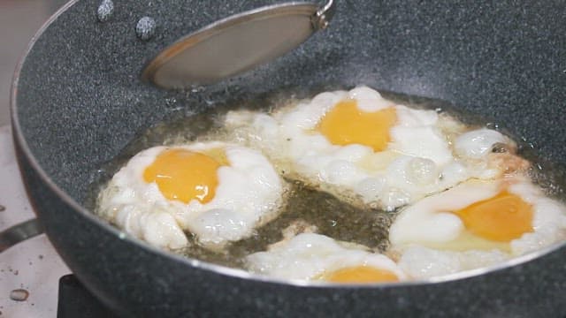 Fried Eggs Cooked in a Pan with Simmering Oil