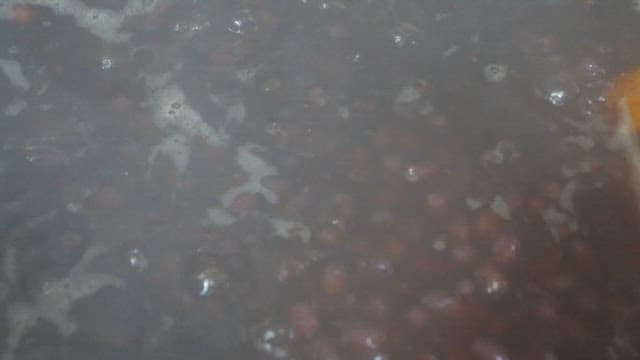 냄비에서 끓여지고 저어지고 있는 팥