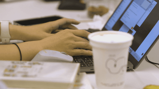 Hands typing quickly on laptop keyboard